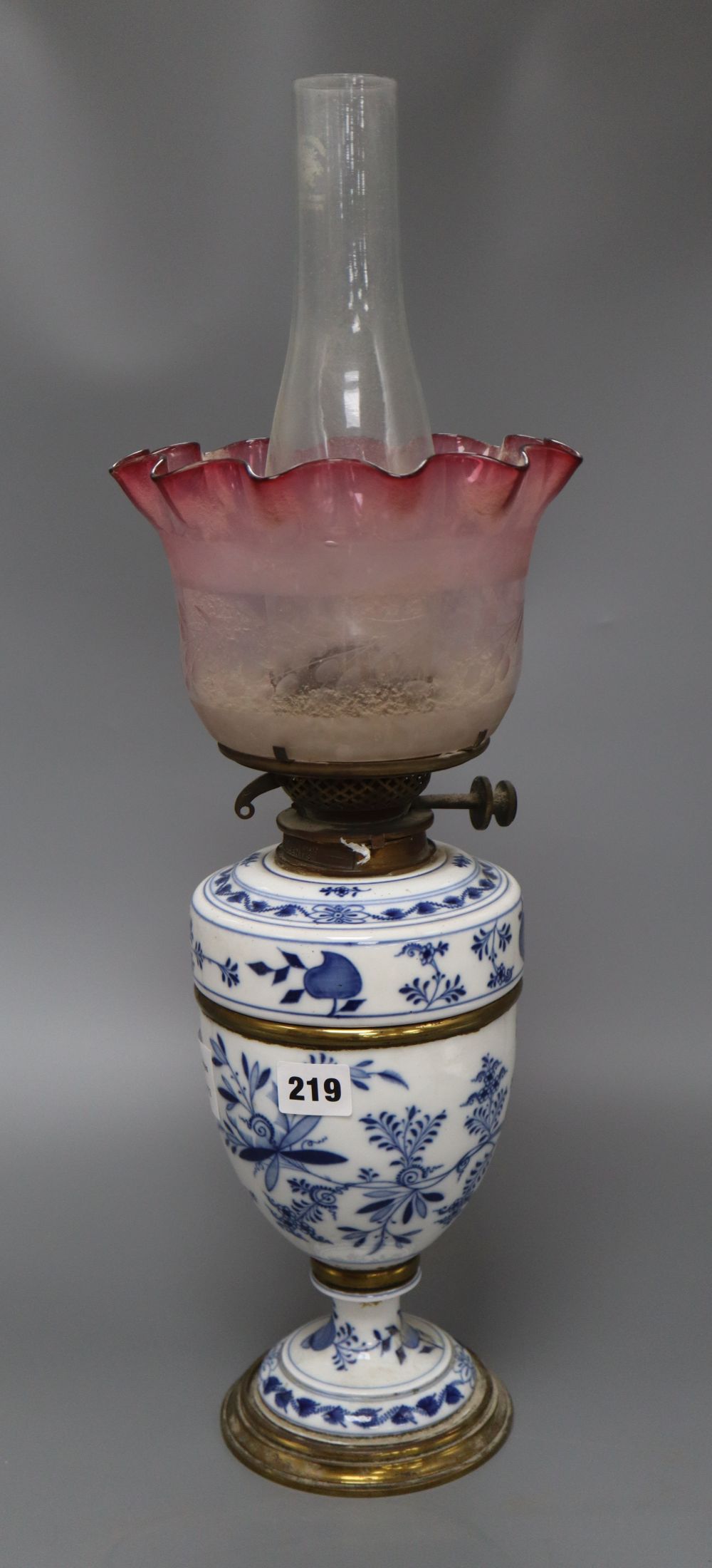 A Meissen onion pattern oil lamp, with cranberry shade